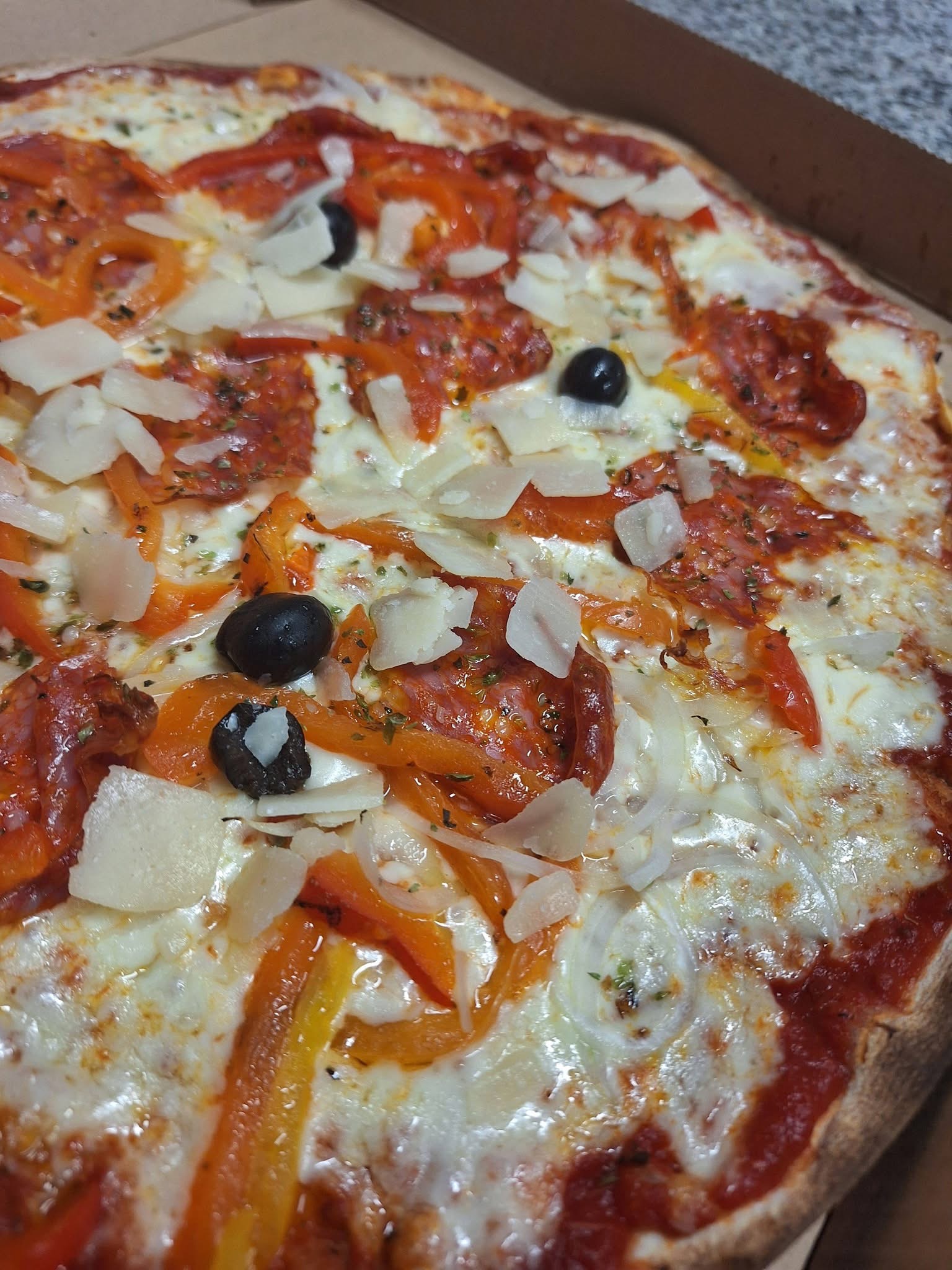 Pizza Piccante au chorizo italien, poivrons, olives et copeaux de parmesan